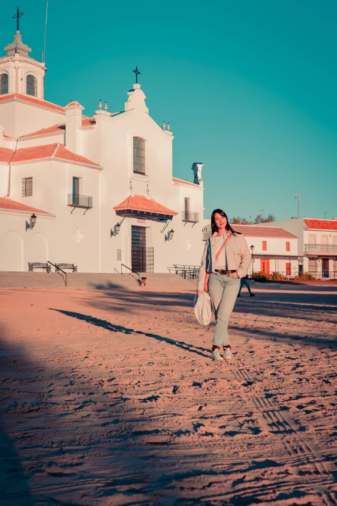 Caroline sobre la arena delante del santuario del Rocío en diciembre
