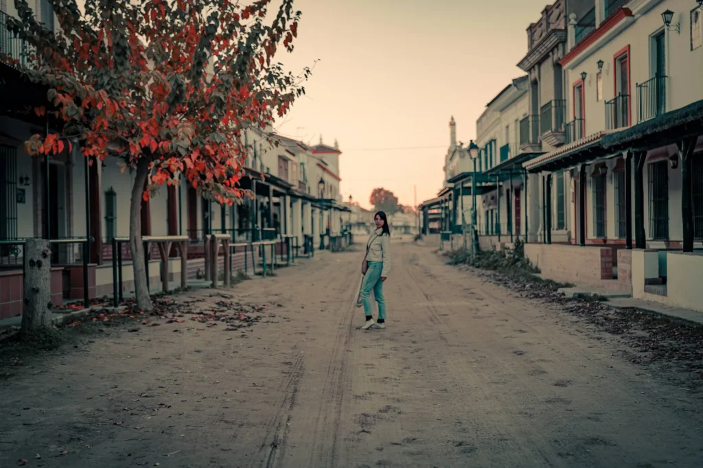 Caroline caminando por una calle de arena de El Rocío al atardecer durante nuestra visita de diciembre