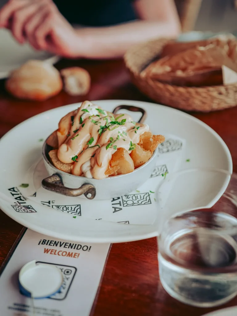 Media ración de patatas bravas con abundante salsa en La Tata, El Rocío