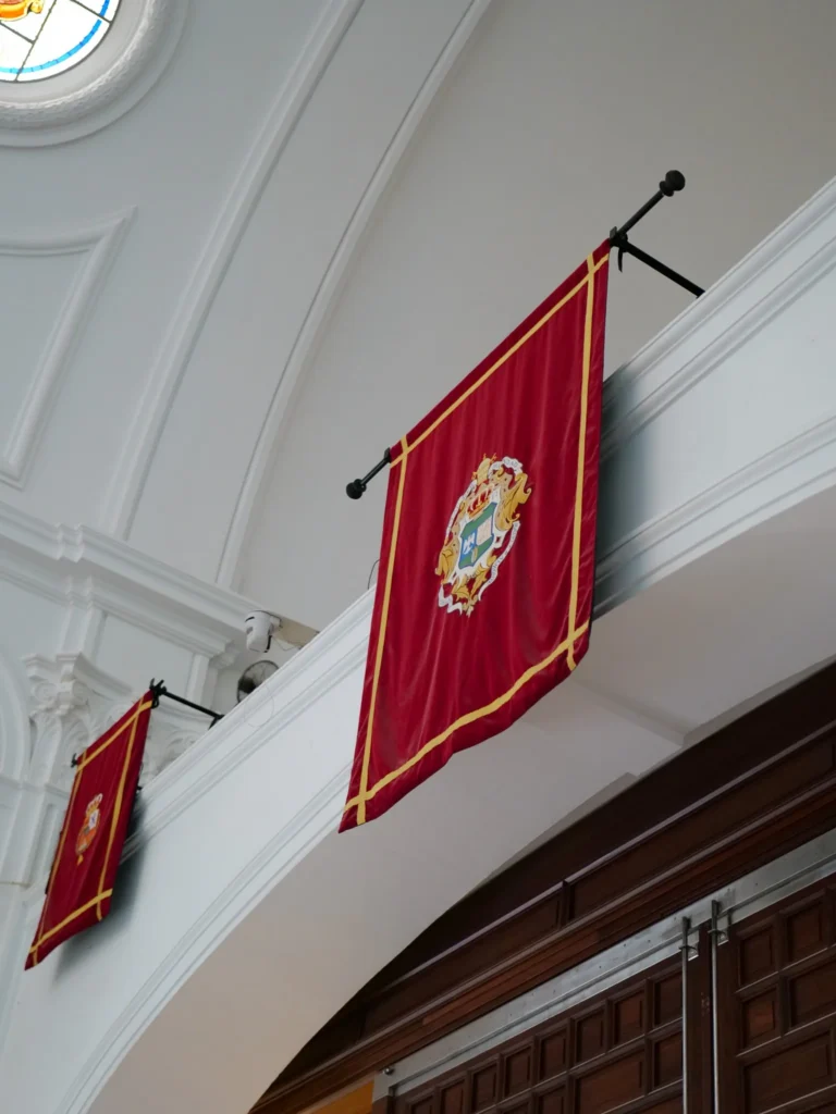 Colgadura roja con el escudo de la Hermandad Matriz de Almonte en el santuario del Rocío
